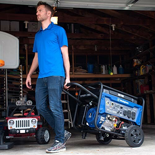 Man moving a portable generator in a garage.